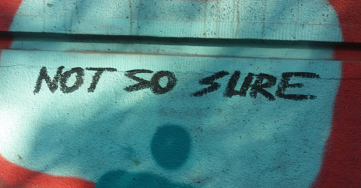 Graffiti on a wall reading NOT SO SURE.